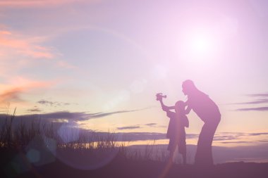 siluet anne ve oğlu oyuncak uçak Günbatımı ile oynamak