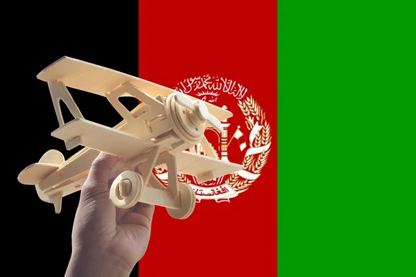 手拿着飞机飞机在阿富汗旗子 旅行概念 — 图库照片