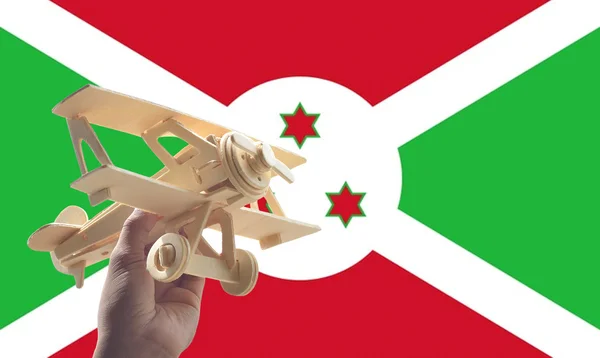 Рука Держит Самолет Над Флагом Бурунди Концепция Путешествия — стоковое фото