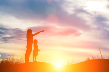 Genç anne silüeti parmak geleceğe işaret.