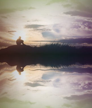 Üzgün çocuk siluet su ile gün batımında çayır üzerinde endişe