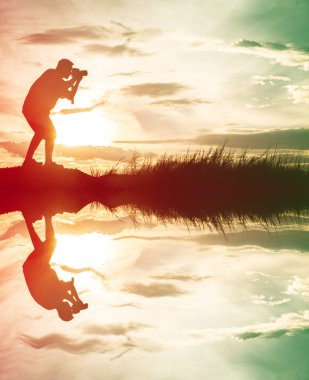 Fotoğrafçı siluet su yansıması ile bir görünüm fotoğraf çekmek