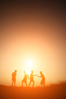 Siluet çocuklar yaz gün batımı mutlu zamanında oyun