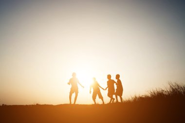 Siluet çocuklar yaz gün batımı mutlu zamanında oyun