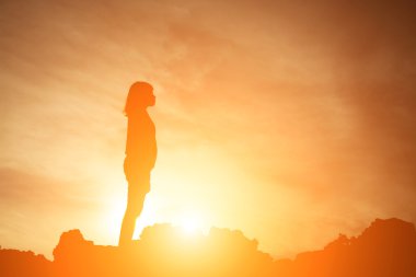 güzel gün batımı sırasında sahasında tek başına duran kadın