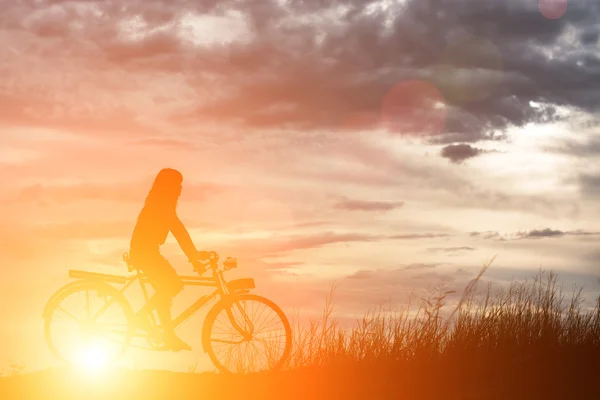 Silhouette of a happy woman outside riding a vintage bicycle — Stock Photo, Image