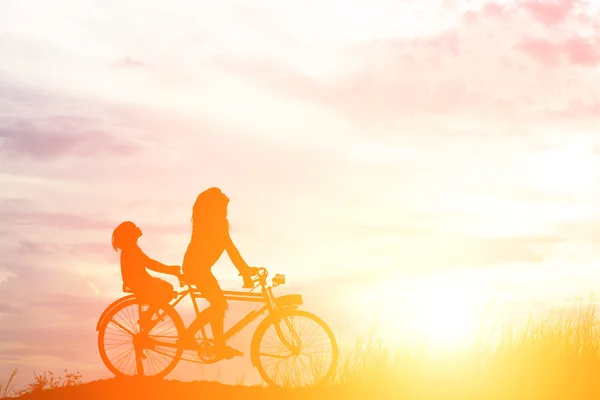 Anne ve kızı sunset happy Time'da bisikleti silüeti — Stok fotoğraf