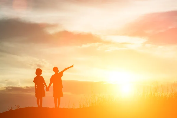 Silhueta menino e menina apontando para o futuro . — Fotografia de Stock