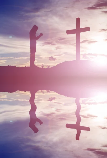 Woman pray with cross silhouette, god concept — Stock Photo, Image