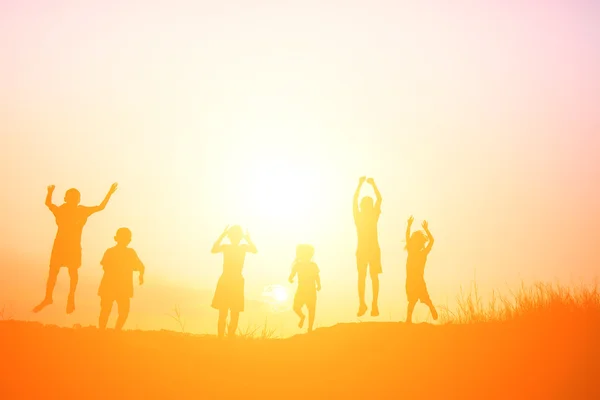 Silhouet van kinderen springen van blijdschap gelukkig tijd — Stockfoto