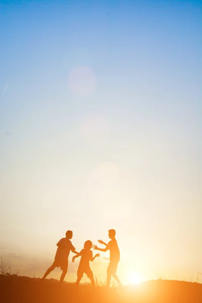 Kinderen spelen op zonsondergang gelukkig zomertijd — Stockfoto