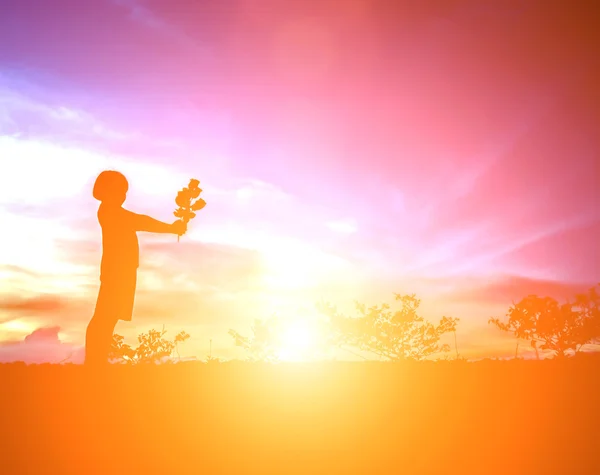 Petite fille avec une fleur à la main. Donne à quelqu'un, Silhouette — Photo