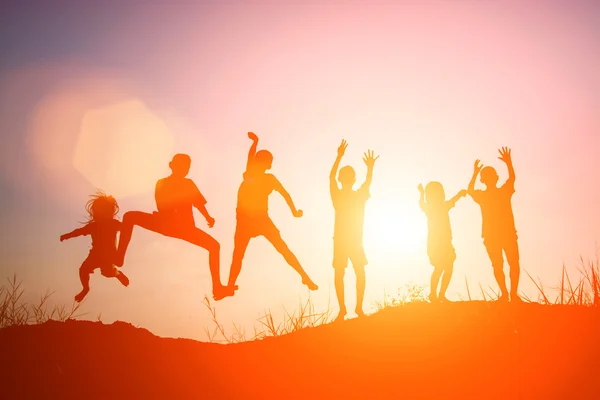 Silhouet van kinderen springen van blijdschap gelukkig tijd — Stockfoto