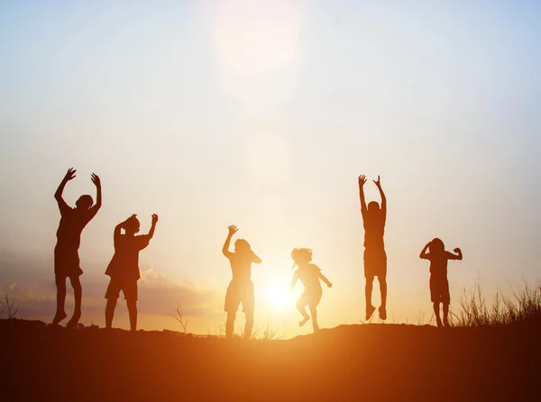 Silueta de los niños saltar alegría feliz tiempo — Foto de Stock