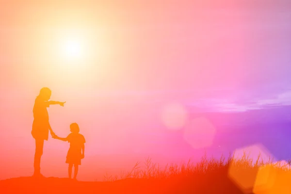 Mutter ermutigte ihren Sohn bei Sonnenuntergang im Freien, Silhouettenkonzept — Stockfoto
