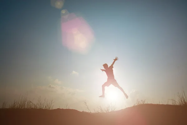 Niño pequeño saltando y teniendo tiempo feliz, concepto de Sillhouette —  Fotos de Stock