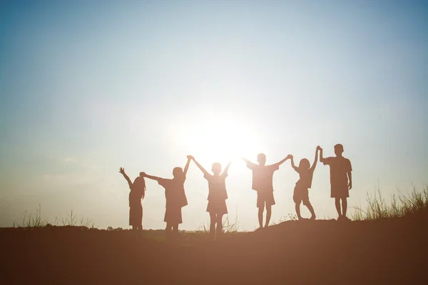 Silueta děti hrající si na letní západ slunce happy time — Stock fotografie