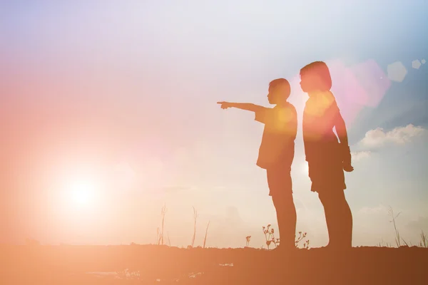 Silhueta menino e menina apontando para o futuro . — Fotografia de Stock