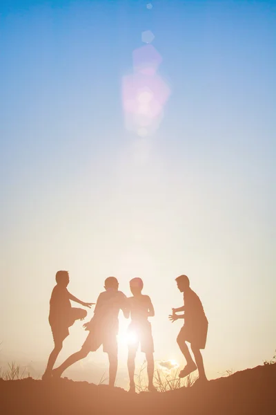 Silueta niños jugando en verano puesta del sol tiempo feliz — Foto de Stock
