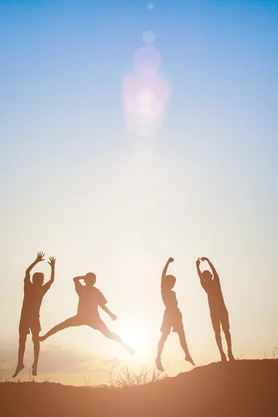 Σιλουέτα παιδιά που παίζουν στην καλοκαιρινή ηλιοβασίλεμα χαρούμενη ώρα — Φωτογραφία Αρχείου