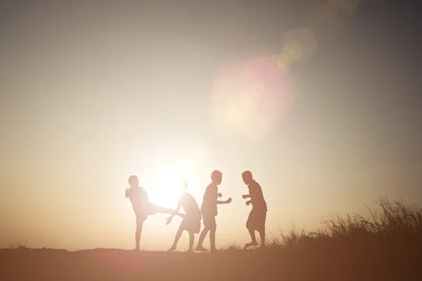Silueta niños jugando en verano puesta del sol tiempo feliz — Foto de Stock