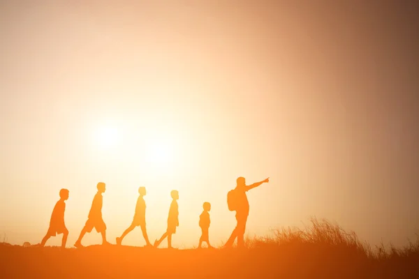 Silhouette padre che cammina con i bambini andare a viaggiare — Foto Stock