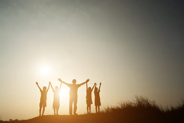 Silueta niños jugando en verano puesta del sol tiempo feliz — Foto de Stock