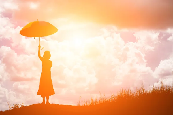 Жінка тримає парасольку, що стоїть на полі під час краси — стокове фото