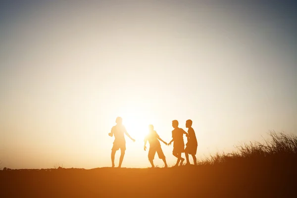 Silhueta Crianças brincando no verão pôr do sol tempo feliz — Fotografia de Stock