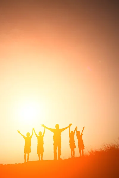 Silueta niños jugando en verano puesta del sol tiempo feliz — Foto de Stock