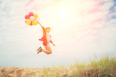 Güzel kız sahilde balonlarla atlama