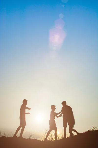 Silhouet van kinderen spelen in de park zonsondergang keer — Stockfoto