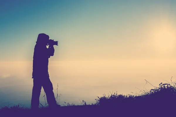 Silhouette of female photographer standing focus for take a phot — Stock Photo, Image