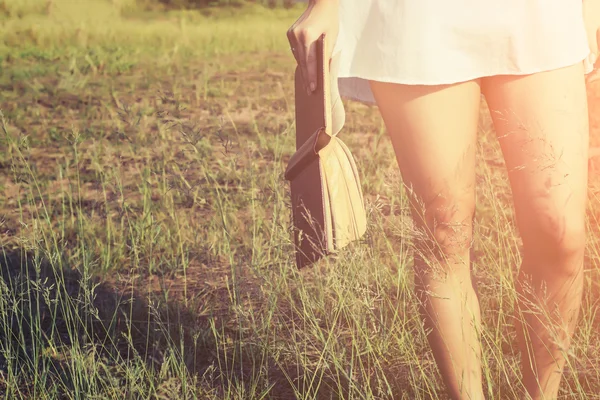 Mujer sosteniendo un libro en los prados en el sol de la mañana . — Foto de Stock