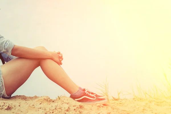 Woman sitting hugging knees with grief.