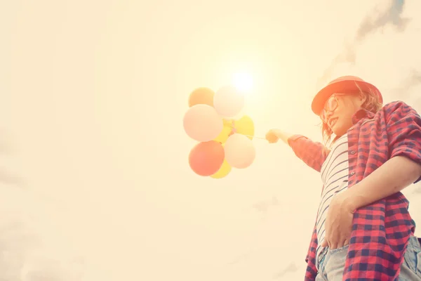 Adolescentes sosteniendo globos de colores en la playa con el bl — Foto de Stock