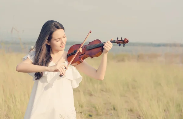 Beautiful Woman standing Playing the violin in the meadow — Stock Photo, Image