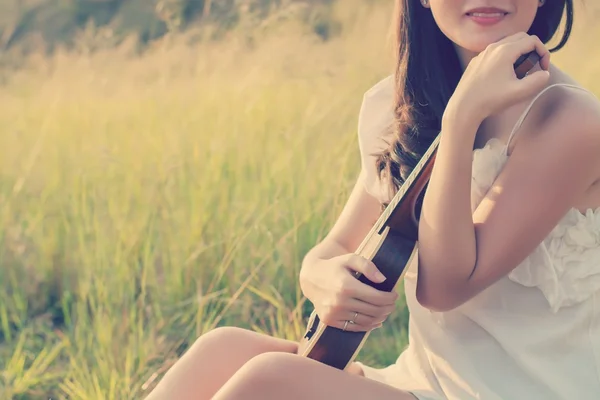 Mulher bonita sentado mão abraços violino no prado — Fotografia de Stock