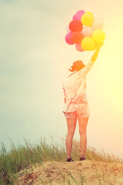 Teenage girls holding colorful balloons in the bright sky and sm — Stock Photo, Image