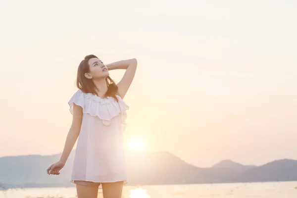 Beautiful young woman standing look at the sky nearing seaside i — Stock Photo, Image