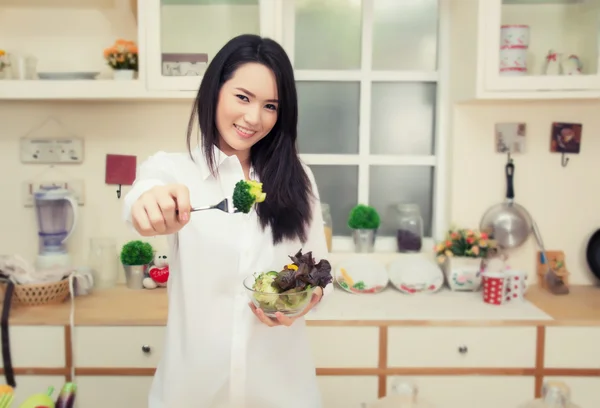 Piękna młoda kobieta jedzenie zdrowe Sałatka w kuchni — Zdjęcie stockowe