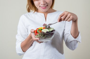 güzel bir kadın ayakta tutan kase salata bazı sebze yemek