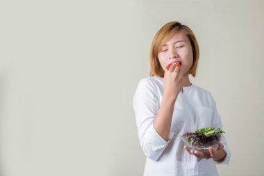 güzel bir kadın ayakta tutan kase salata bazı sebze yemek