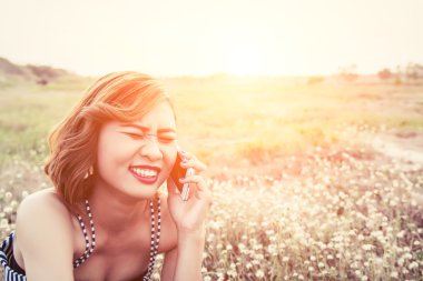 summe çiçek alanında bir smartphone kullanarak seksi güzel kadın