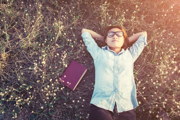 Joven hipster mujer acostada en el campo de flores después de que se cansó para re — Foto de Stock