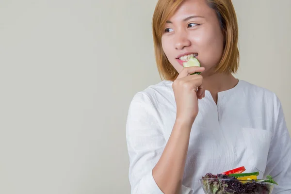 Gyönyörű nő állandó üzem eszik néhány hálók zöldség saláta tál — Stock Fotó