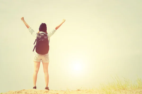 Young woman carrying backpack put her hands up — Stock Photo, Image