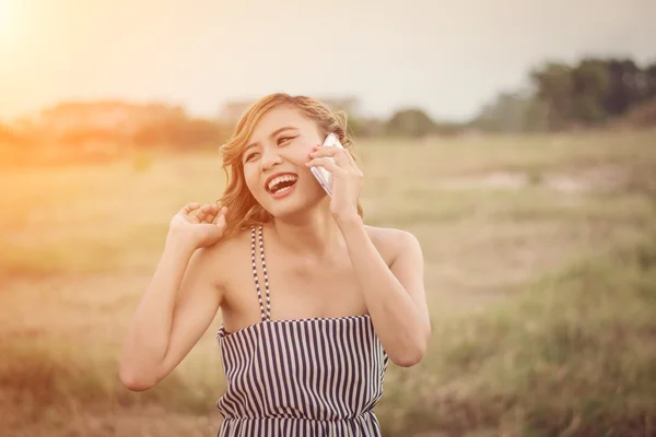 Belle femme sexy debout parlant au téléphone dans le champ d'herbe — Photo