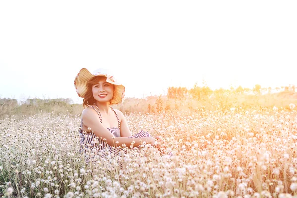 Sexy piękna kobieta nosi kapelusz i buźkę siedzi w fi kwiat — Zdjęcie stockowe