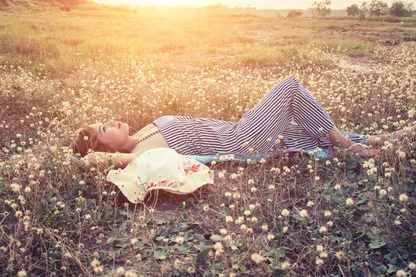 Joven mujer sexy tumbada en la hierba cerca de su sombrero — Foto de Stock